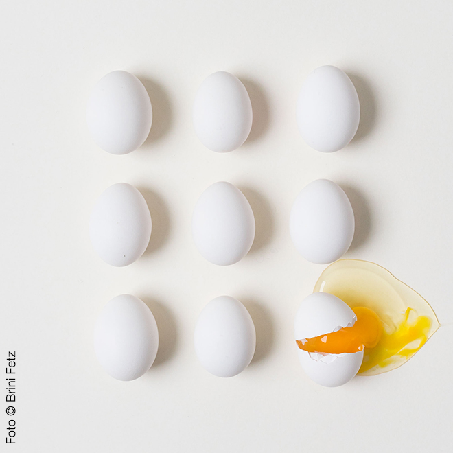 Dekoratives Bld, das Eier zeigt, von denen eines aufgeschlagen ist